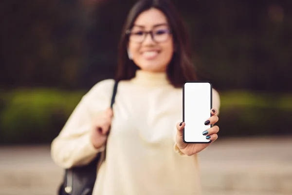 Imagen burlona de la niña mostrando el teléfono con pantalla en blanco — Foto de Stock