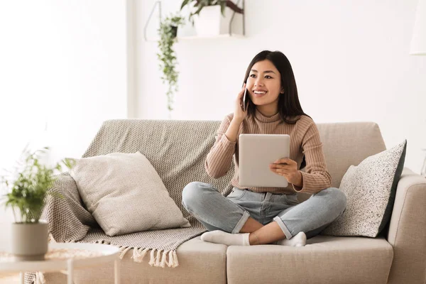 Teen κορίτσι χρησιμοποιώντας το tablet και μιλάει στο τηλέφωνο — Φωτογραφία Αρχείου