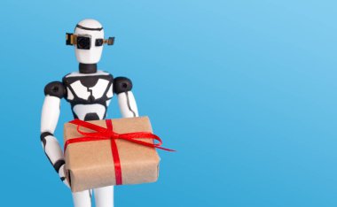 Hediye kutusu tutan küçük robot, boş alana sahip mavi arka plan.