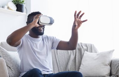 Gözlüklerini evde deneyen neşeli bir adam.