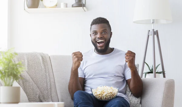 Emocionado cara negro assistindo esportes na TV em casa — Fotografia de Stock