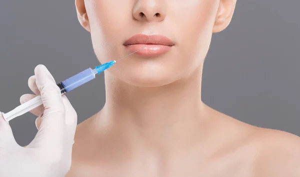 Beautician making beauty injection into female lips — Stock Photo, Image