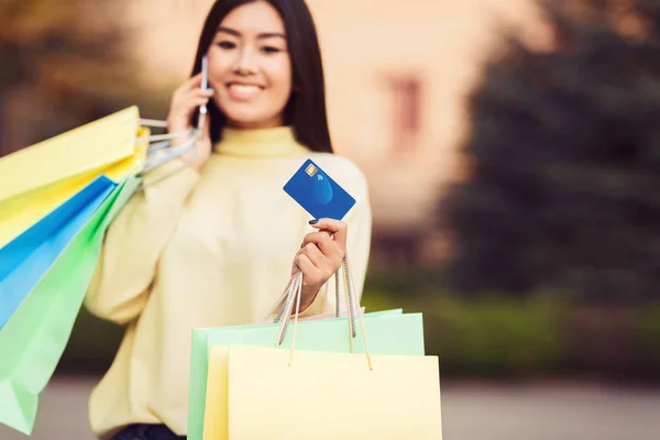 Asiatisk tjej med shoppingväskor och kreditkort — Stockfoto