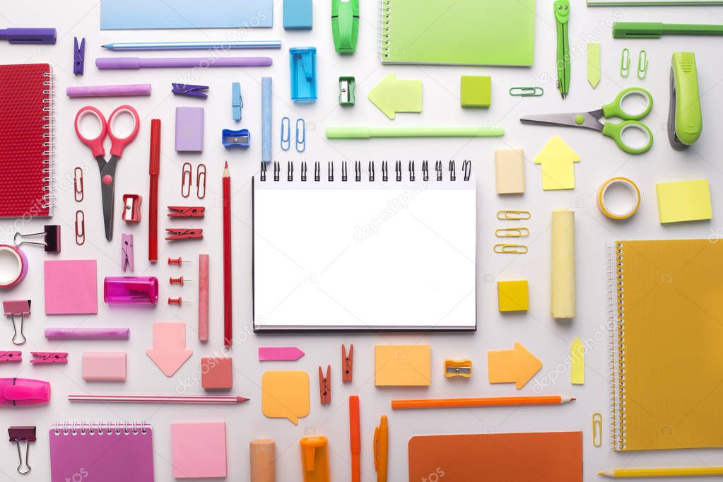 Office supplies around notepad with white blank space