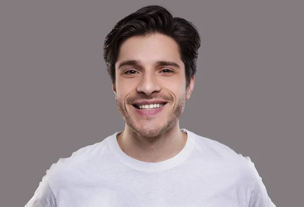 Przystojny młody kaukaski mężczyzna uśmiechnięty w aparat fotograficzny — Zdjęcie stockowe