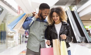 Mutlu afrikalı amerikalı çift alımları tartışıyor ve gülümseyerek