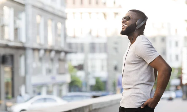 Веселий африканський хлопець в навушниках насолоджується прослуховуванням музики — стокове фото