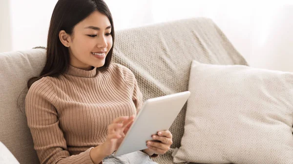 Happy Girl läsa E-bok på digital Tablet, vilar på soffan — Stockfoto