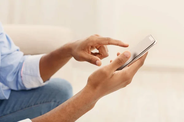 Young man using modern smartphone at home — Stock Photo, Image