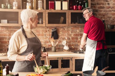 Pozitif emekli çift mutfakta, akşam yemeği için hazırlanıyor