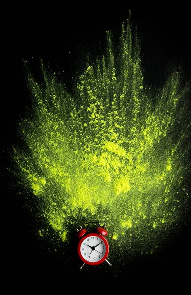Sveglia rossa con esplosione di polvere di oli gialli su nero — Foto Stock