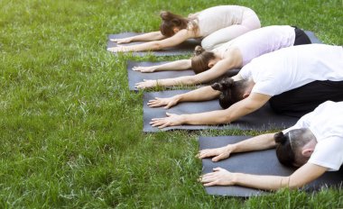 Yoga paspasları üzerinde yatan bir grup insan Çocuk poz yapma