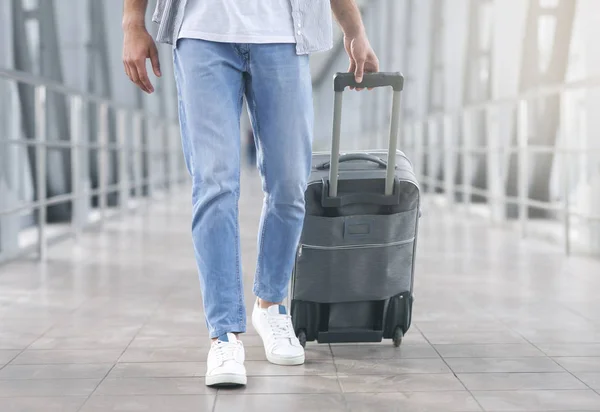 Homem caminhando com bagagem no corredor do aeroporto — Fotografia de Stock