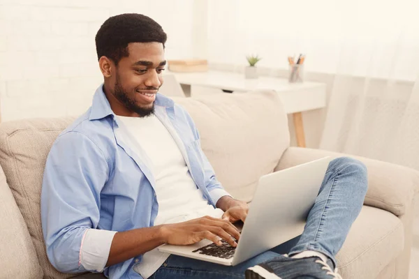 Young man working on laptop online at home — Stock Photo, Image