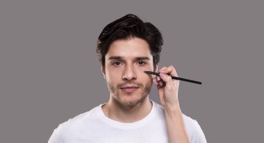 Cerrah erkek yüzünde kalemle işaretler çizer