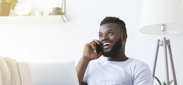 Millennial hombre hablando por teléfono celular y utilizando el ordenador portátil —  Fotos de Stock