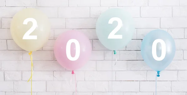 Set of four colorful balloons with white text on bricks wall — Stock Photo, Image