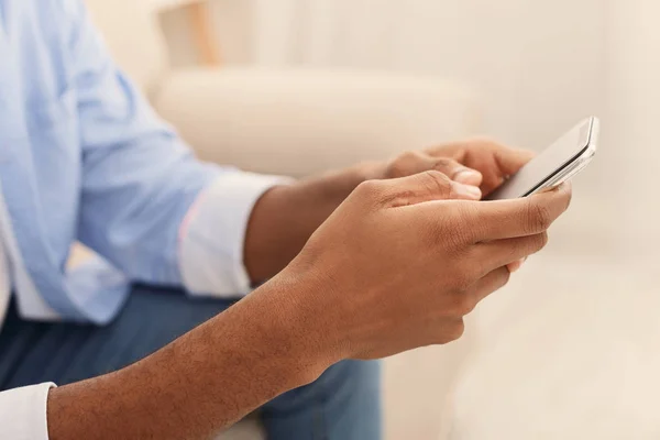 Young man using modern smartphone at home — Stock Photo, Image