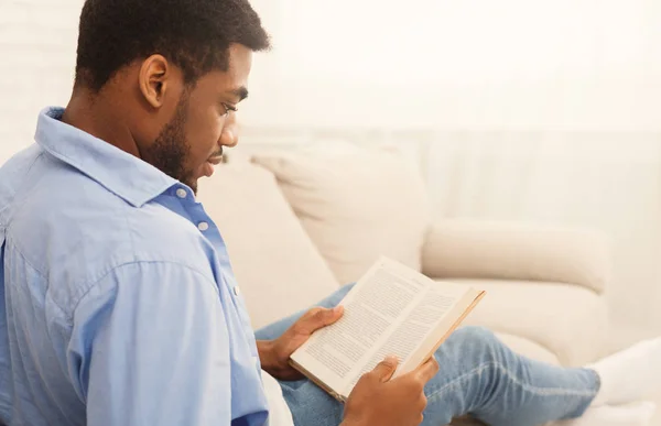 Nero maschio studente lettura libro a casa — Foto Stock
