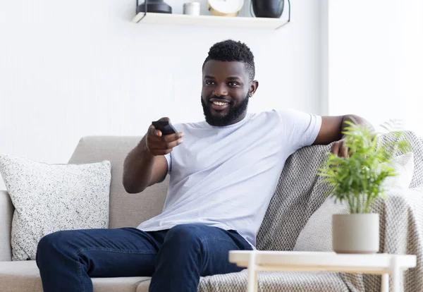 Joven hombre afroamericano viendo la televisión en casa — Foto de Stock