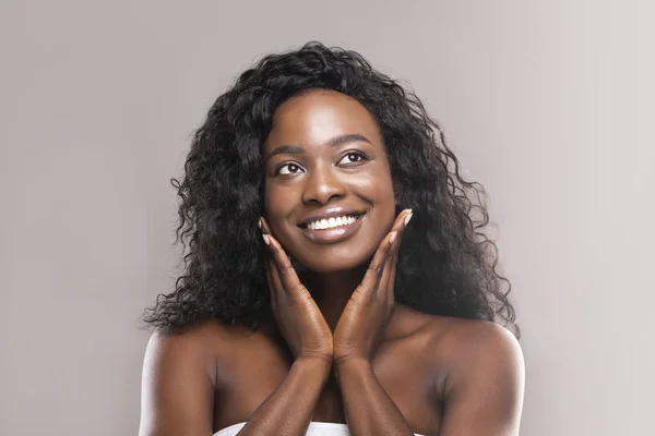 Young black woman applying moisturizer cream on her face — Stock Photo, Image