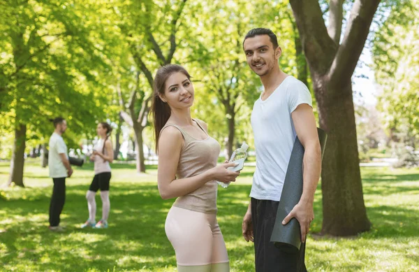 Atraente jovem casal posando para câmera depois de treinar ao ar livre — Fotografia de Stock