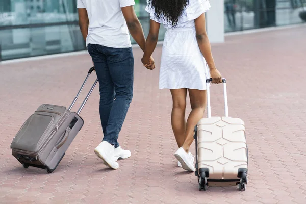 Pareja africana caminando con maletas en el aeropuerto — Foto de Stock