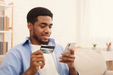 Adam kredi kartı tutan ve online alışveriş için akıllı telefon kullanma