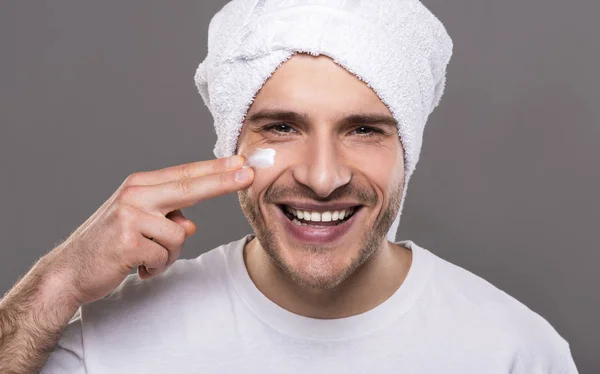 Hombre alegre guapo se preocupa por la belleza con toalla en la cabeza — Foto de Stock