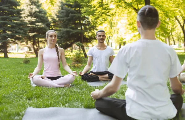 Profesora de Yoga y principiantes en clase outdoor, haciendo posturas fáciles — Foto de Stock