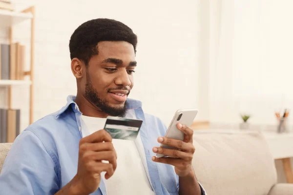 Hombre con tarjeta de crédito y el uso de teléfono inteligente para compras en línea —  Fotos de Stock