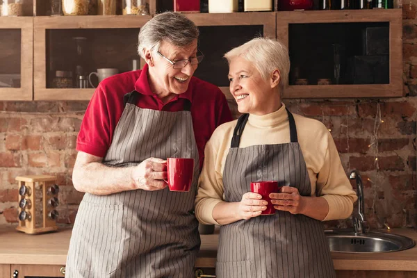 Mayores casados disfrutando de un tranquilo comienzo del día en la cocina —  Fotos de Stock