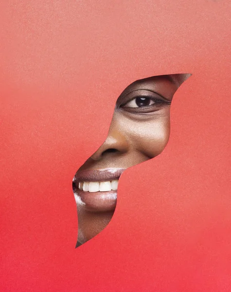 Parti del viso femminili con trucco artistico dietro il foro di carta — Foto Stock