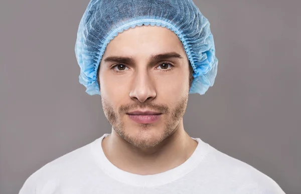 Πορτρέτο του νεαρού άνδρα με μπλε ιατρικό καπέλο — Φωτογραφία Αρχείου