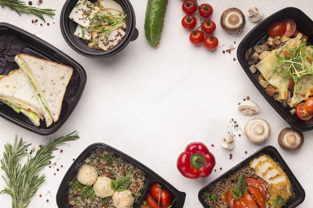 Healthy food delivery in black boxes with tasty meal on white