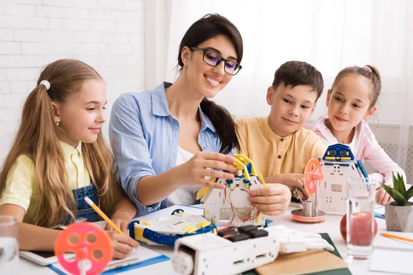 Kids creating robots with teacher at stem education class — Stock Photo, Image