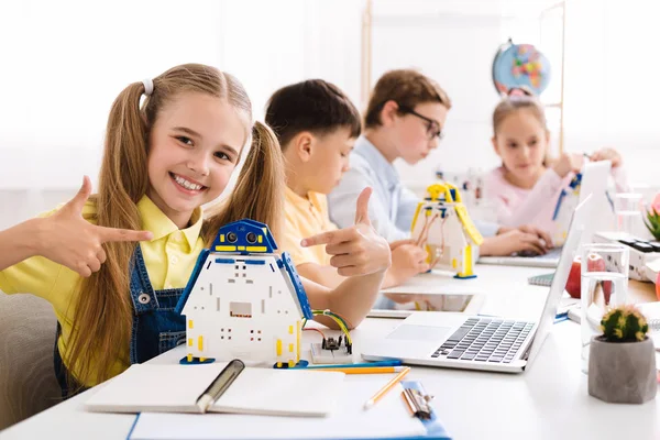 Girl showing her robot. Proud student of her project — Stock Photo, Image