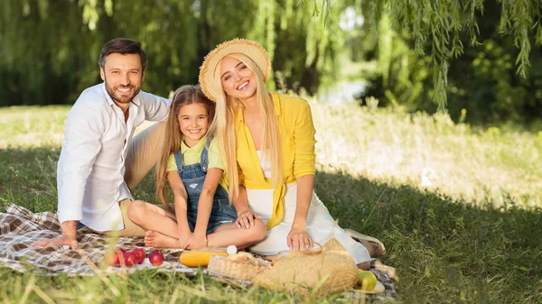 Familje picknick. Föräldrar och dotter vilar i naturen — Stockfoto