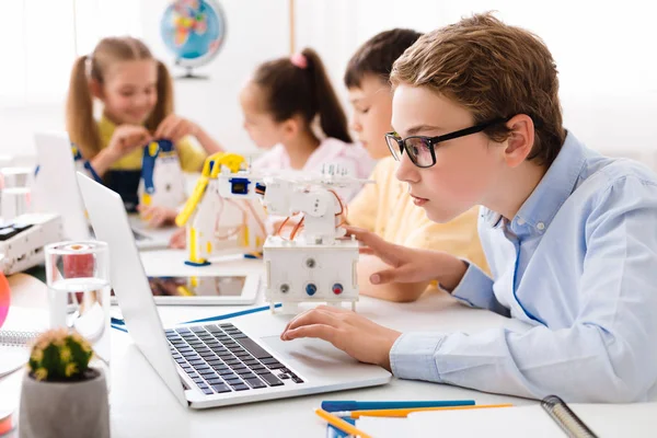 Jongen met laptop, montage robot in de klas — Stockfoto