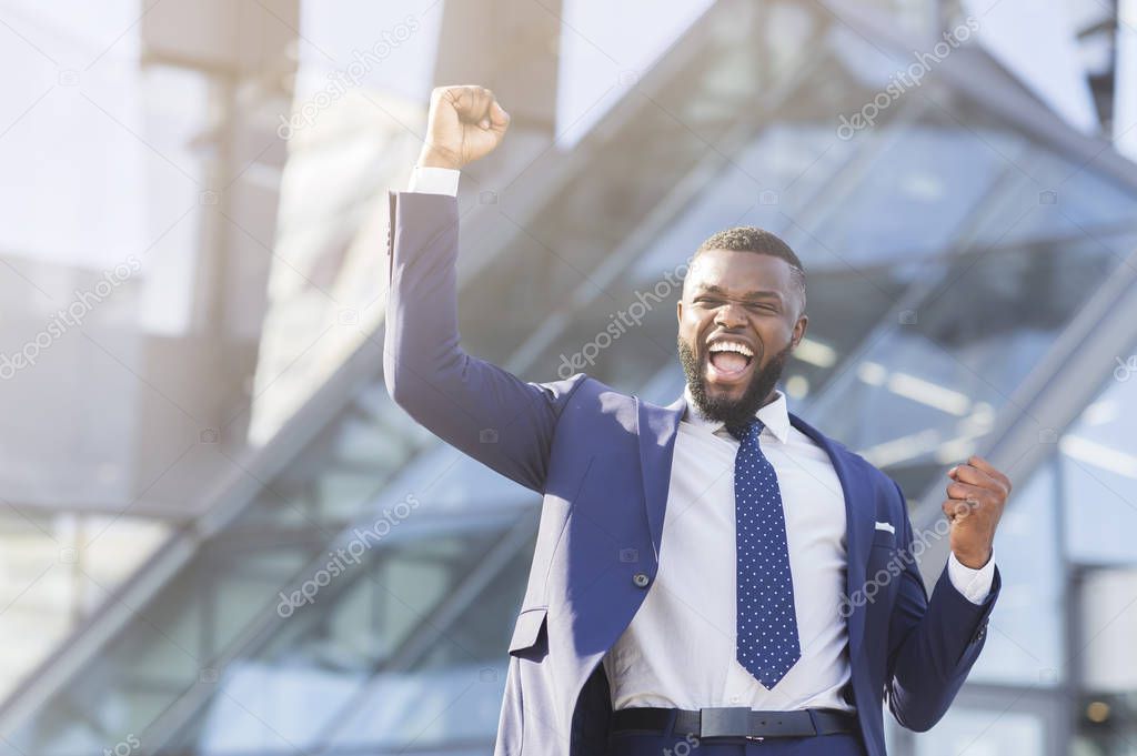 African American Man Shaking Clenched Fists Celebrating Business Success Outdoor