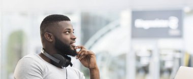 Düşünceli Afrikalı adam bir kafede oturan ve uzağa bakıyor