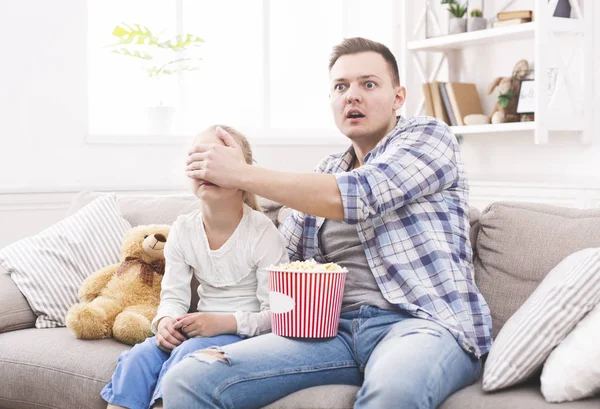 Padre sta chiudendo gli occhi di sua figlia mentre guarda il film — Foto Stock