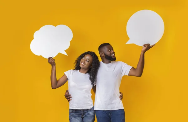 Молодая африканская американская пара держит пузыри общения в студии — стоковое фото