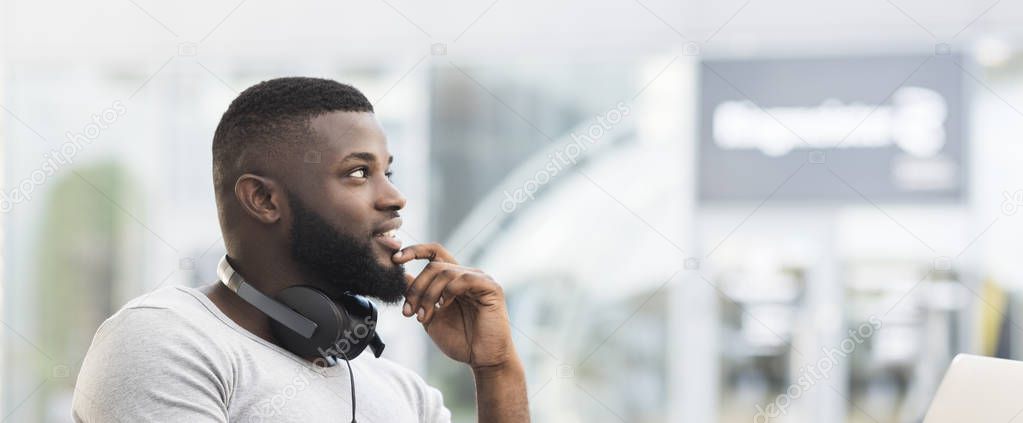 Thoughtful african man sitting in a cafe and looking away