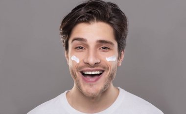 Neşeli bin yıllık adam yüzünde krem şımartan zevk