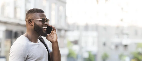 Усміхнений африканський чоловік розмовляє на мобільному телефоні з близьким другом — стокове фото