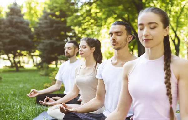 Grupo de amigos meditando no parque — Fotografia de Stock