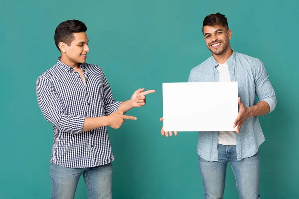 Dos hombres sonrientes con ropa casual mostrando pizarra blanca en blanco —  Fotos de Stock