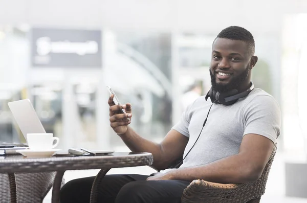 Ευτυχισμένος Αφρικανός Αμερικανός τύπος καθιστός καφέ με δωρεάν WiFi — Φωτογραφία Αρχείου
