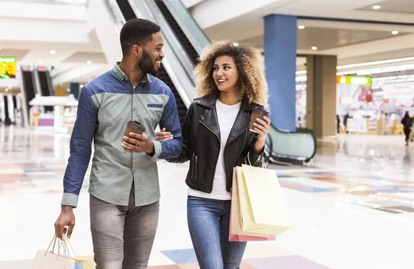 Couple africain joyeux avec café à emporter et sacs en papier — Photo